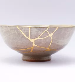 Conceptual, ceramic bowl with light showing through cracks.