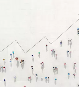 Birds-eye view of people arranged in the shape of a graph with an arrowing suggesting an increase overtime.
