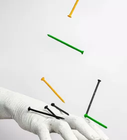 nails falling onto a statue of a human hand.