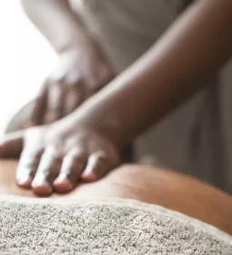 A Black MT lays flat palms on a client's back.
