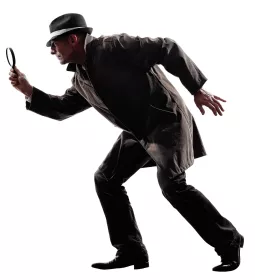 Detective in a coat and hat with a magnifying glass tiptoeing.