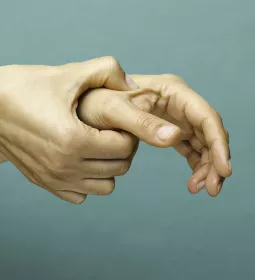 Self-massage of right hand on the left hand's thumb.