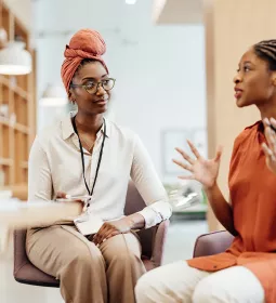 Two women are seated in conversation.