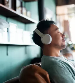 A man sits back and relaxes with his headphones on.