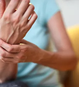 A female grasps her wrist.