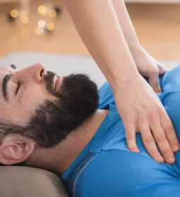 A massage therapist works on a client's pectorals.