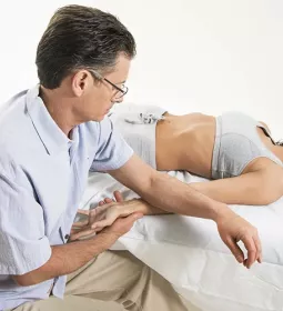 Uncross the Wires Til Luchau works on a supine client's wrist.