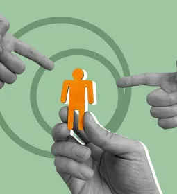One hand holds up a cutout of a person, while two other hands point at the figure.