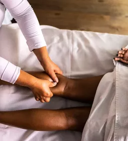 A massage therapist works on a client's calf.