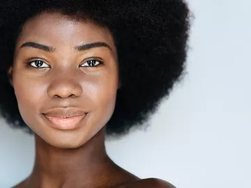 A Black woman smiles at the camera.