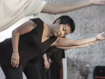 People go through movement exercises, balancing on one leg and extending one arm.