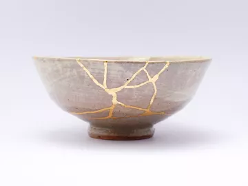 Conceptual, ceramic bowl with light showing through cracks.