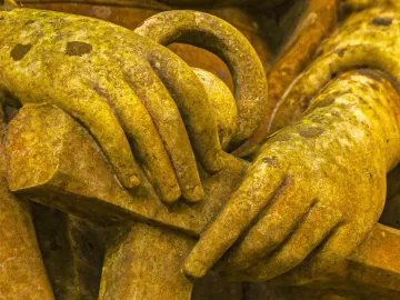 A statue's hands are the focus of an image.