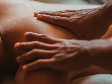 Two hands of an MT on a person's back.