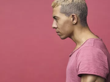 lateral view of a man in a pink shirt with his head and neck angled forward.