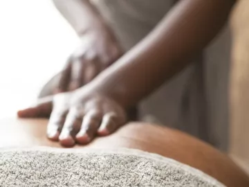 A Black MT lays flat palms on a client's back.