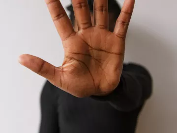 Man holding hold up to demonstrate stopping. 