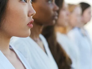 A line of women of all different skin tones, colors, and hair styles, facing to the right.