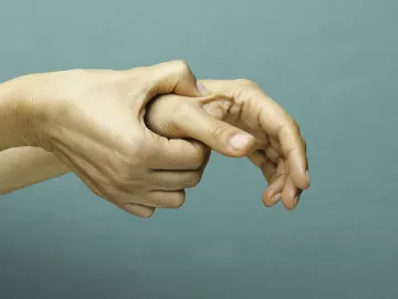 Self-massage of right hand on the left hand's thumb. 