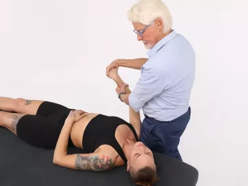 Massage therapist Erik Dalton massages a client's right arm.