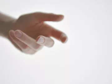 a person's hand reaching outward.
