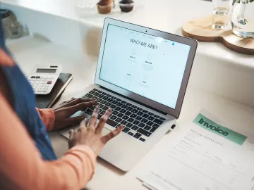A person uses a laptop to create a website for their business.