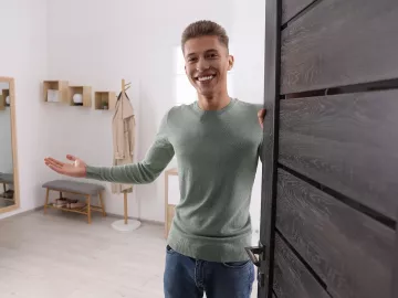 Welcoming male MT opens a door to a session room.