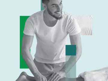 A massage therapist works on a prone client's lower leg.