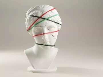 A cracked statue bust with bands around it holding it together.