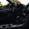 a steering wheel and a black drivers seat interior of a car. 