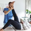 A massage therapist moves a client's leg upward.